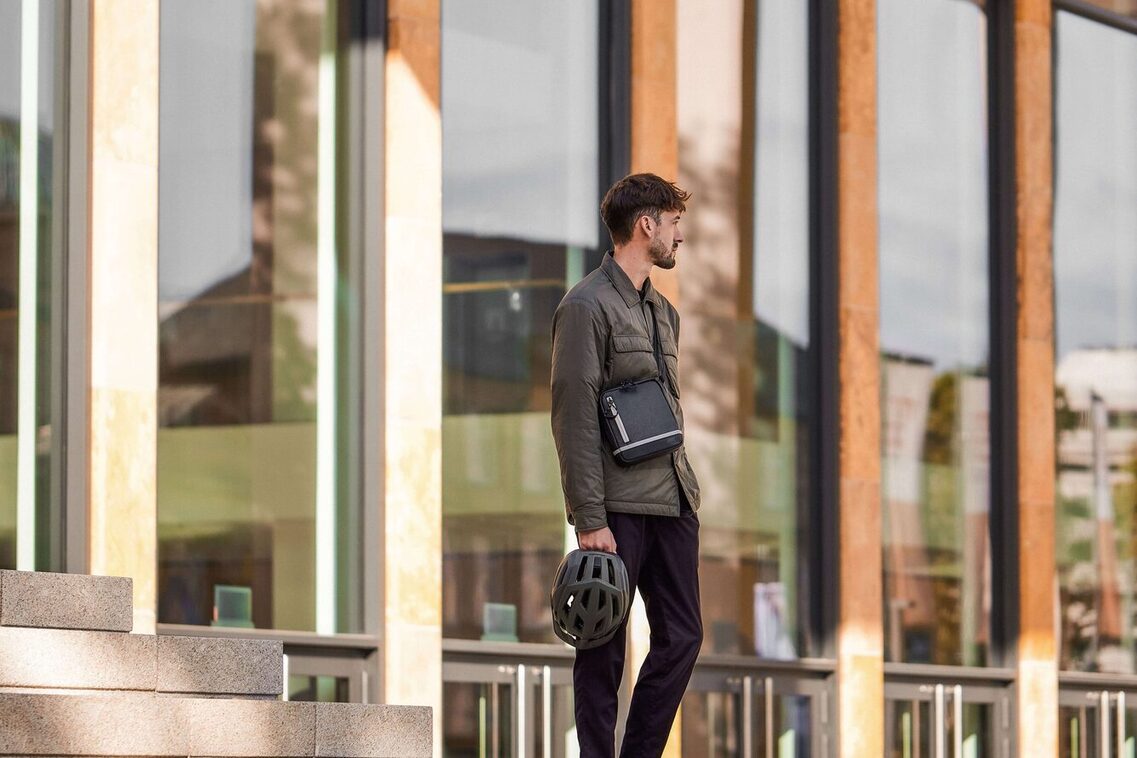 Un hombre de pie en la escalera sosteniendo un casco