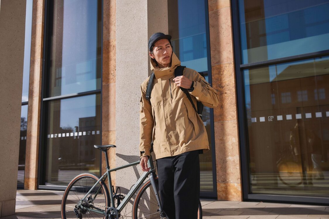 Ein Mann mit dem Fahrrad steht vor dem Gebäude