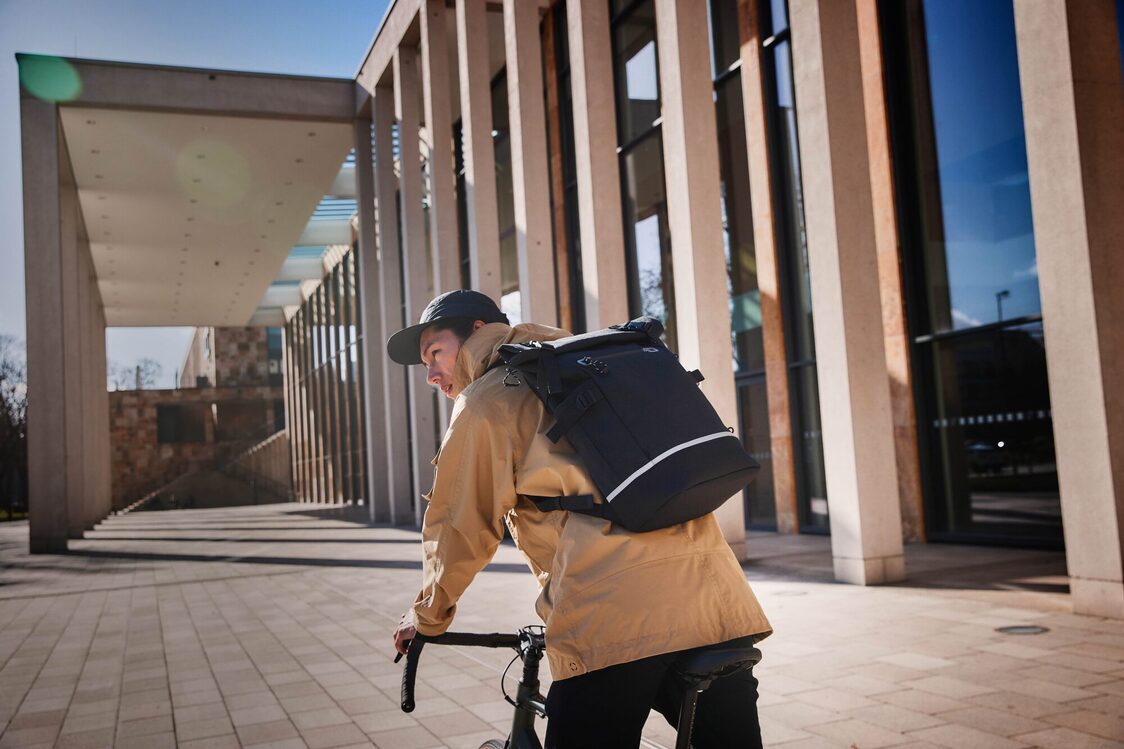 Ein Mann mit einem schwarzen Rucksack fährt mit dem Fahrrad