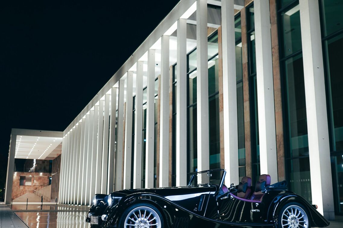 Coche antiguo delante de los pilares del RMCC