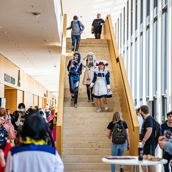 Drei Menschen in Manga-Kostümen gehen die Treppe runter