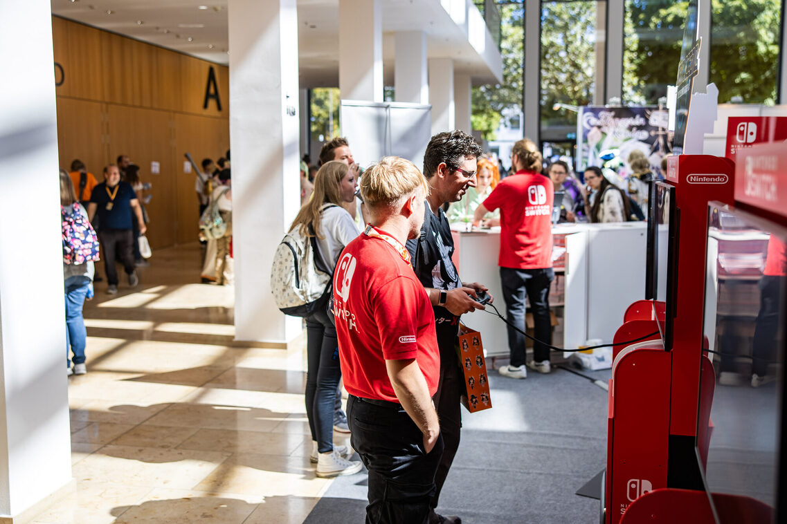 Veranstaltungsgäste spielen Nintendo im Foyer Zentral
