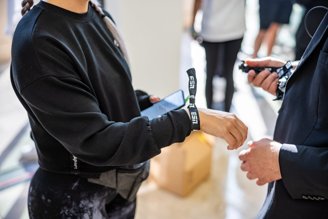 Ein Mann trägt ein Bändchen "ESN"