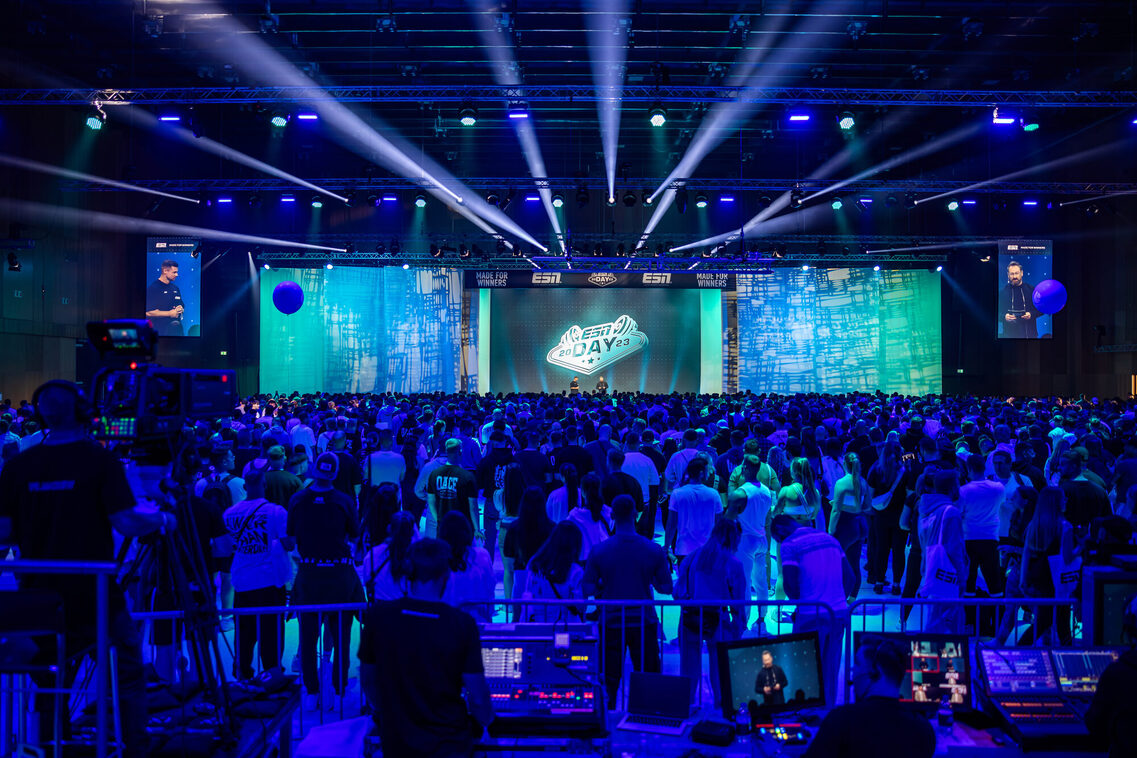 Veranstaltungsgäste stehen vor der Bühne