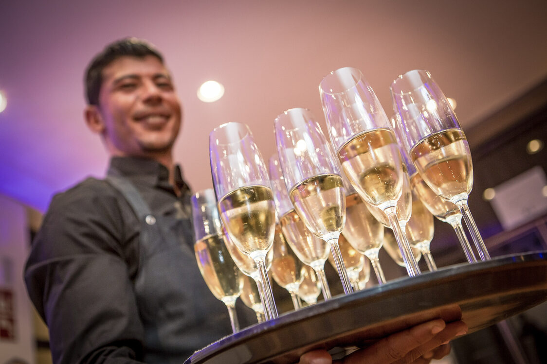 Ein Kellner hält ein Tablet mit Sekt