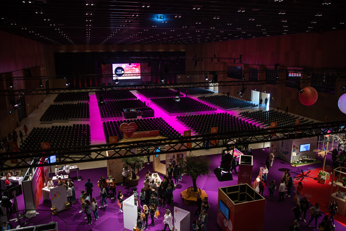 Reihenbestuhlung in der Halle Nord im RMCC, Veranstaltungsgäste in der Messehalle