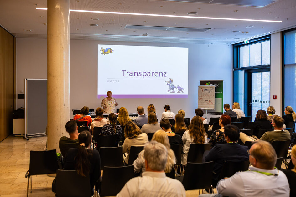 Etkinlik konukları oturur ve konferansı dinler.