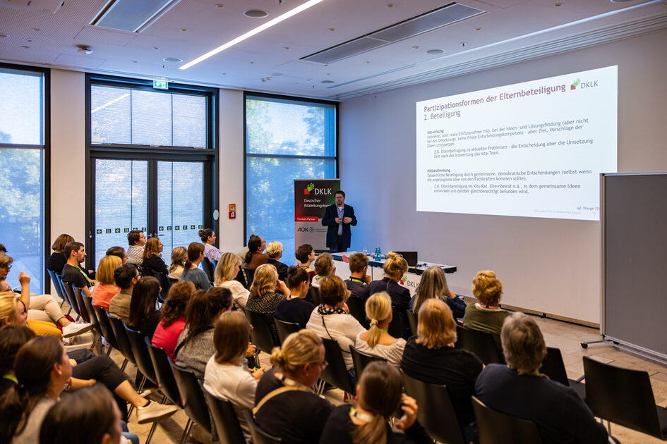 Etkinlik konukları oturur ve konferansı dinler.