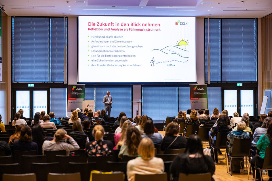 Etkinlik konukları oturur ve konferansı dinler.