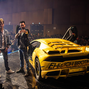 Ehrlich Brothers stehen auf der Bühne mit eienem gelben Auto