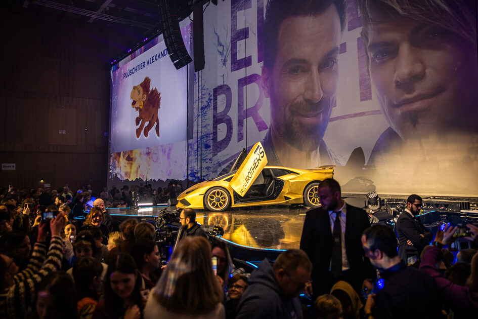 Sahnede seyircilerin önüne sarı bir araba park edilmiştir