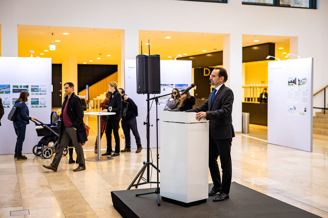 Ein Mann hält Rede während der Ausstellungseröffnung.