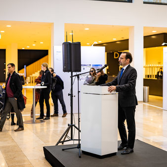 Ein Mann hält Rede während der Ausstellungseröffnung.