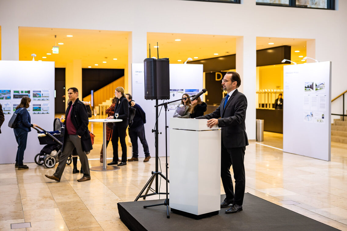 Ein Mann hält Rede während der Ausstellungseröffnung.