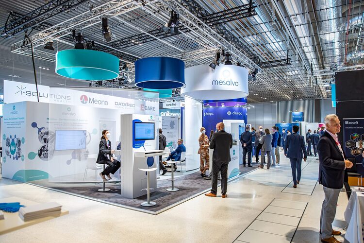Kongressgäste am Messestand