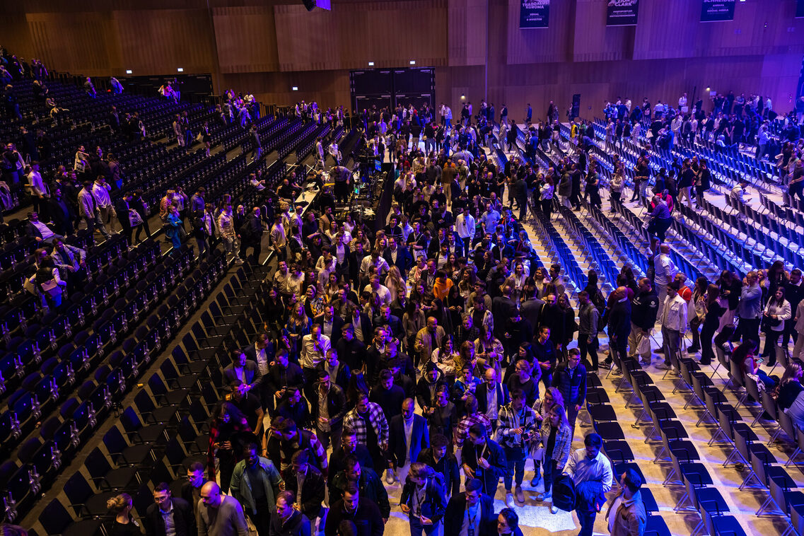 Publikum steht zwischen den Sitzreihen in der Halle