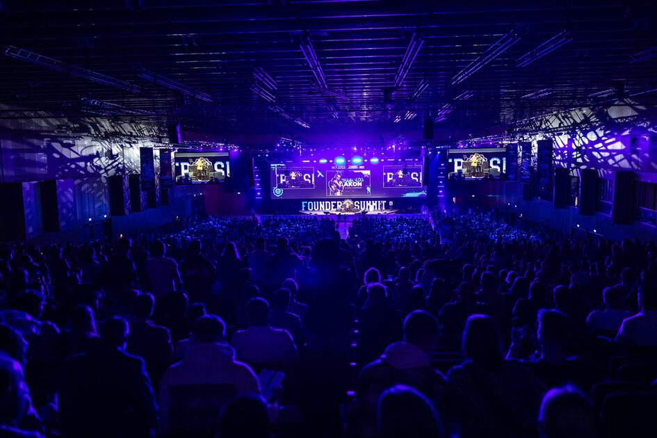 Bir konuşmacı izleyicilerin önünde sahneye çıkar