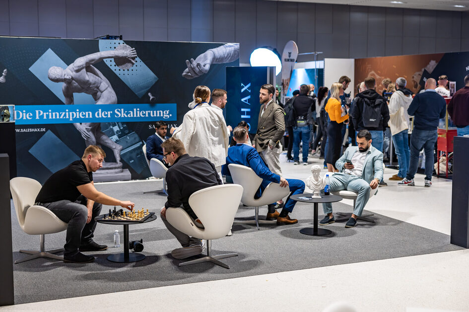 Etkinlik konukları sandalyelere oturur ve sohbet eder