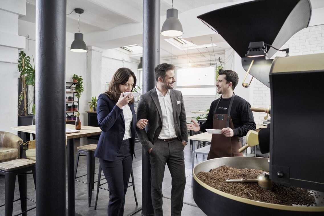 Ein Mann und eine Frau riechen Kaffeebohnen in der Kafferösterei