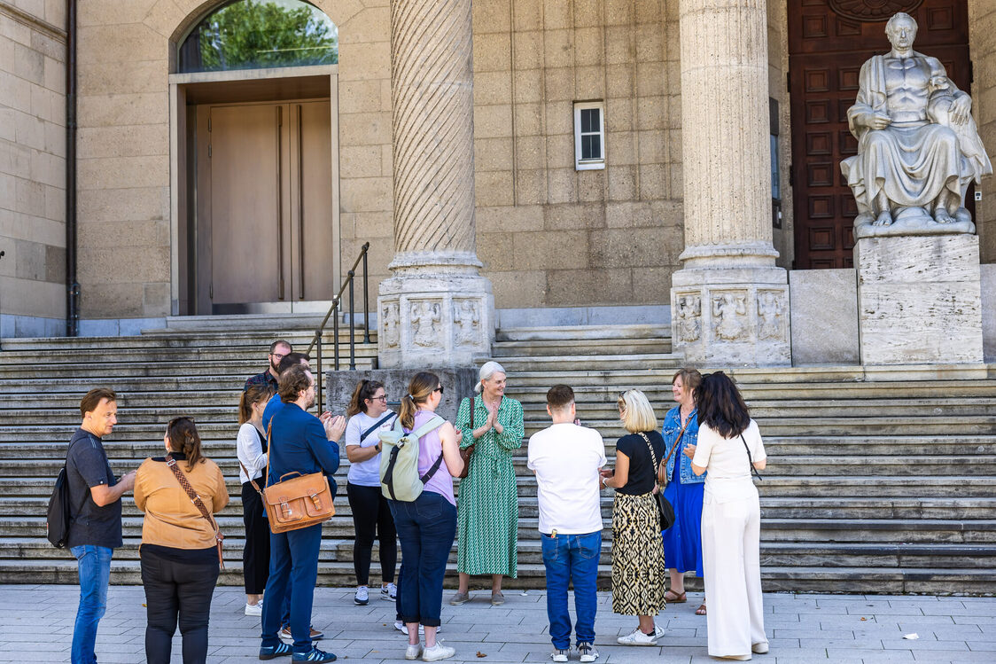 Stadtgäste während einer Führung stehen vor dem Museum