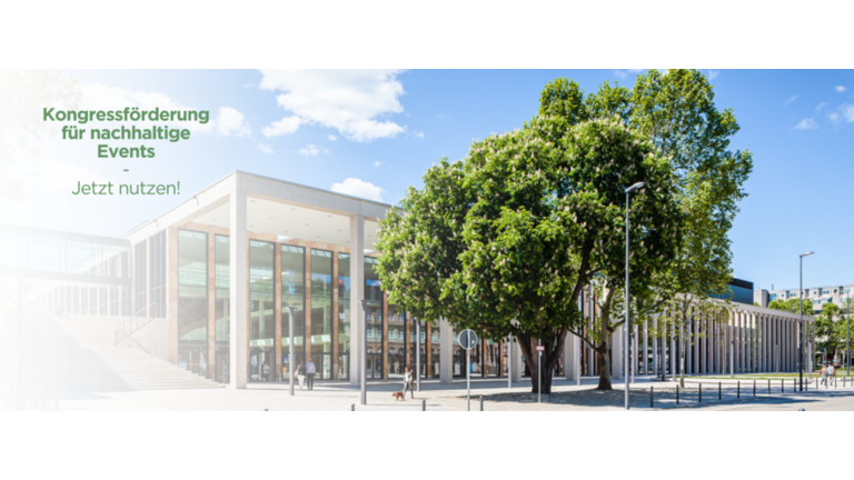 Außenansicht RMCC Wiesbaden mit Störer darüber, der auf das neue Förderprogramm von nachhaltigen Events hinweist.