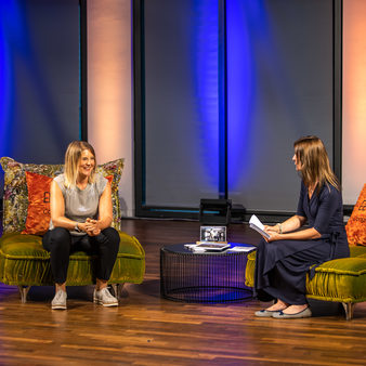 Eine Frau sitzt auf dem Sofa und interviewt eine andere Frau